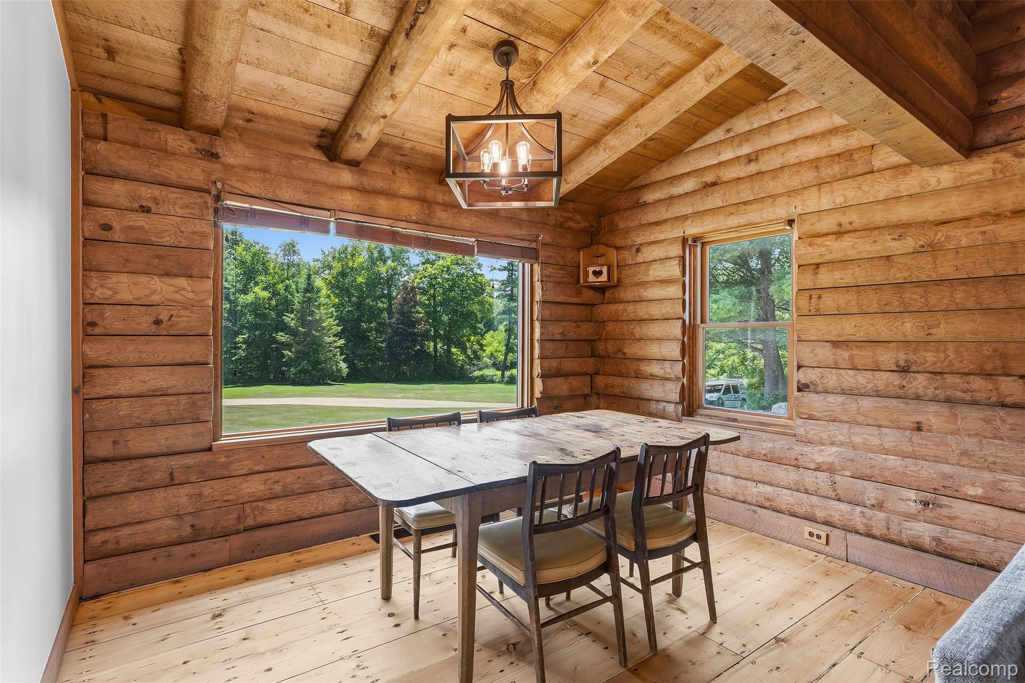 3656 Stanley Road Columbiaville, MI 48421 - Photo 10 of 65 Rustic interior featuring extensive wood paneling, exposed wood ceiling beams, wood-finish flooring, and multiple windows