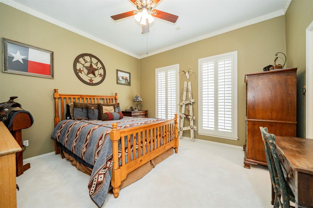 9511 Fallbrook Drive Dallas, TX 75243 - Photo 32 of 40 a bedroom with a bed and a chandelier