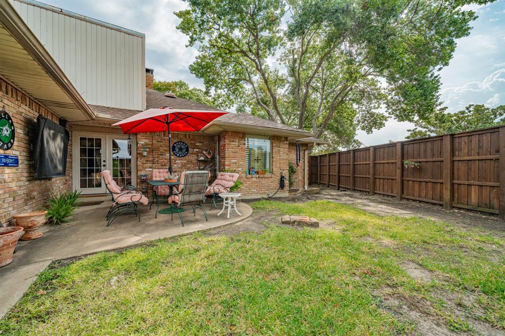9511 Fallbrook Drive Dallas, TX 75243 - Photo 38 of 40 a view of a patio with table and chairs under an umbrella