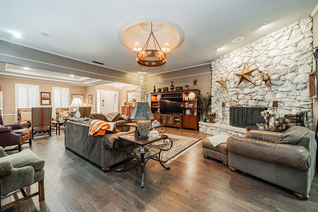 9511 Fallbrook Drive Dallas, TX 75243 - Photo 8 of 40 a living room with furniture a fireplace and a chandelier