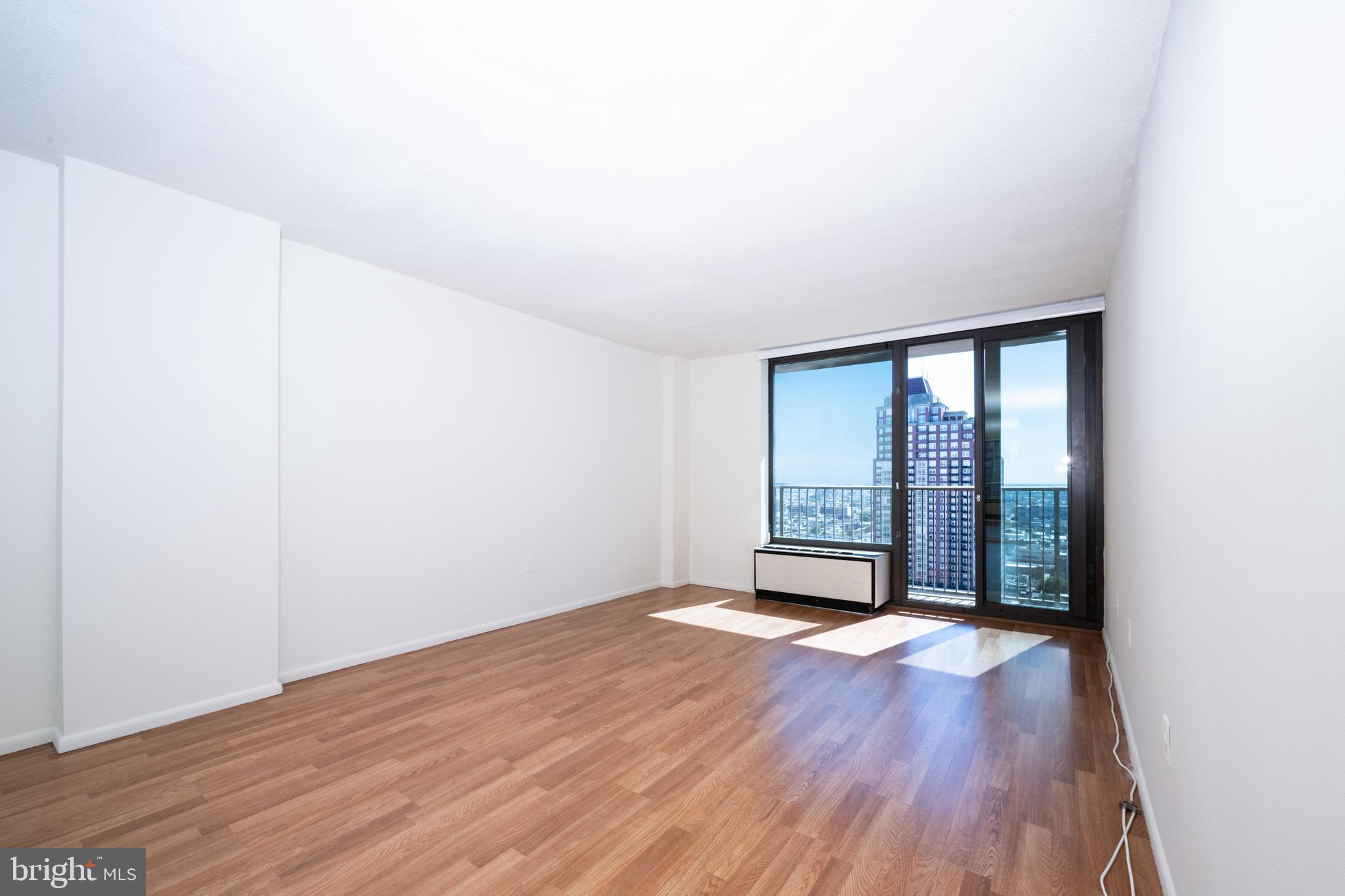 1420 Locust Street, Unit 24R Philadelphia, PA 19102 - Photo 1 of 31 an empty room with wooden floor and windows