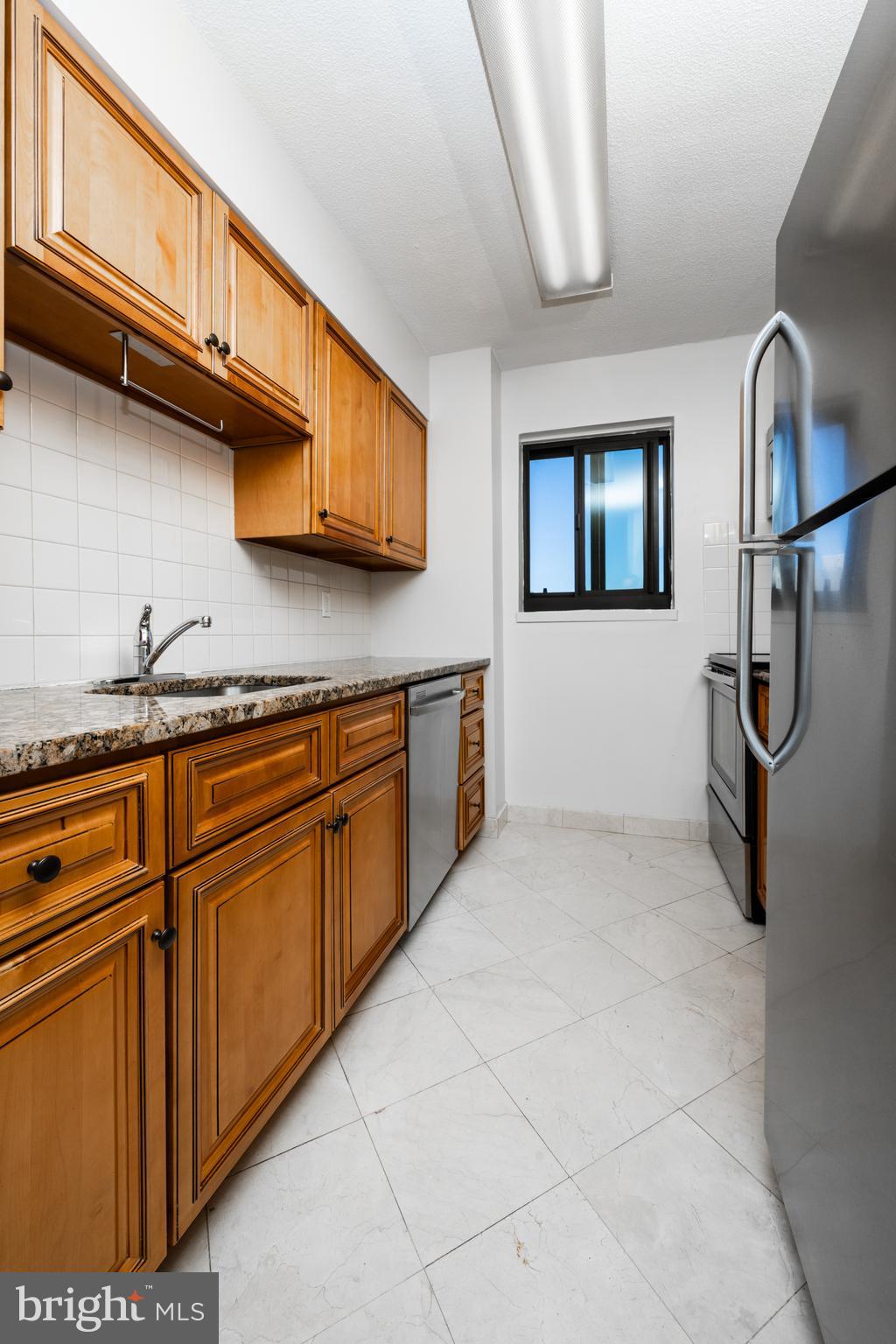 1420 Locust Street, Unit 24R Philadelphia, PA 19102 - Photo 11 of 31 a kitchen with stainless steel appliances granite countertop a refrigerator and a stove top oven