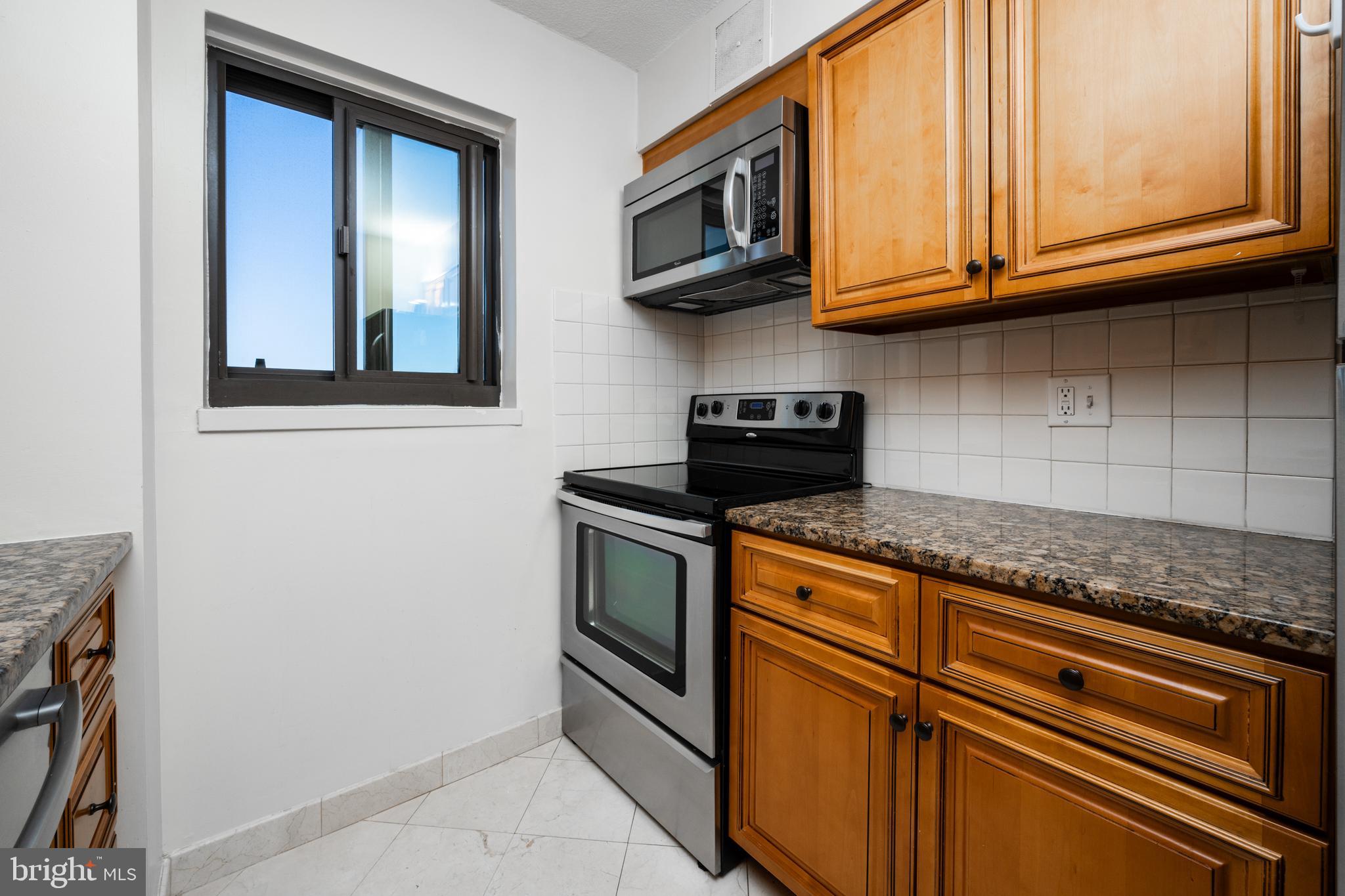 1420 Locust Street, Unit 24R Philadelphia, PA 19102 - Photo 12 of 31 a kitchen with stainless steel appliances granite countertop a cabinets and a microwave