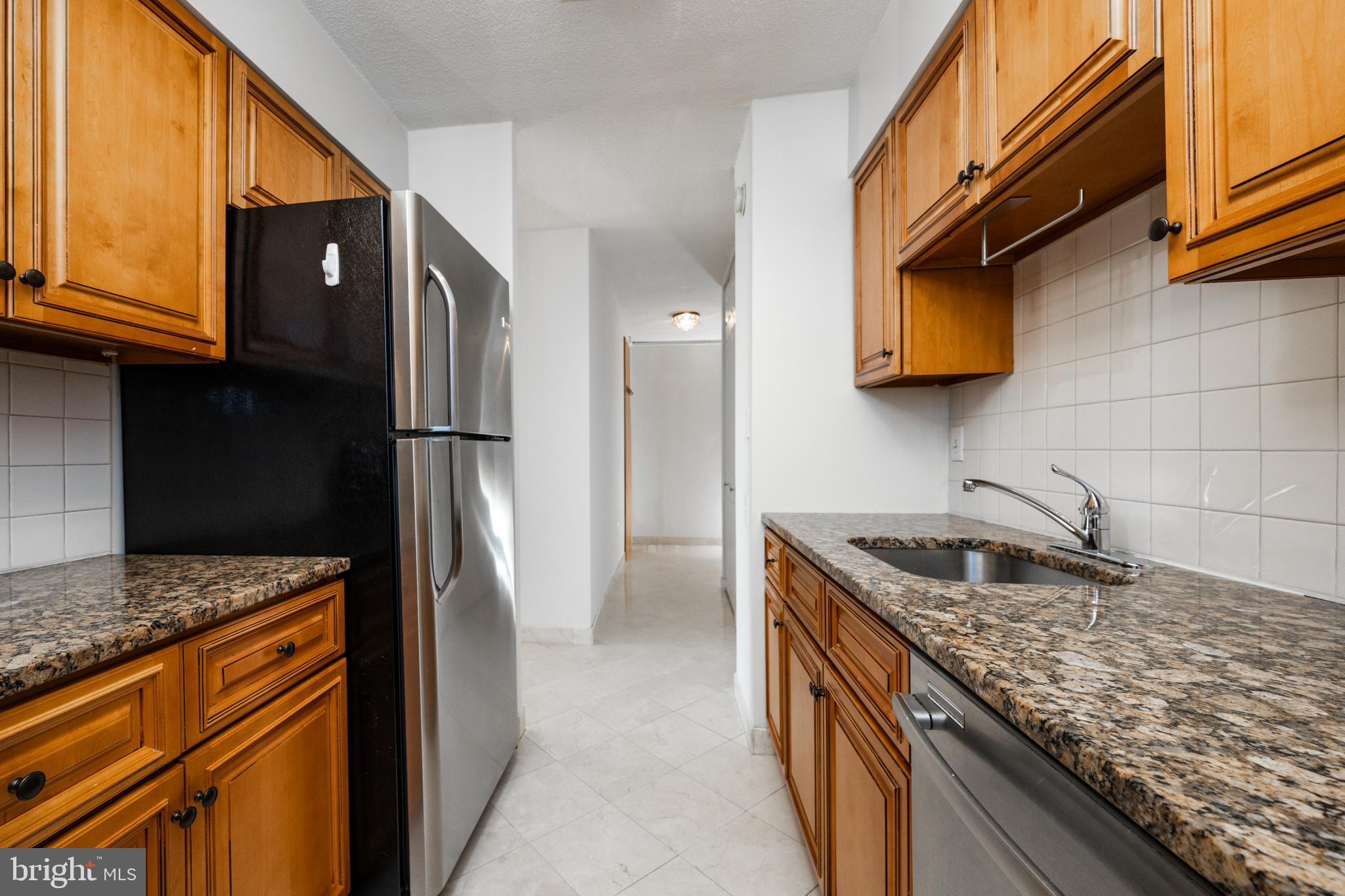 1420 Locust Street, Unit 24R Philadelphia, PA 19102 - Photo 15 of 31 a kitchen with stainless steel appliances granite countertop a sink stove and refrigerator