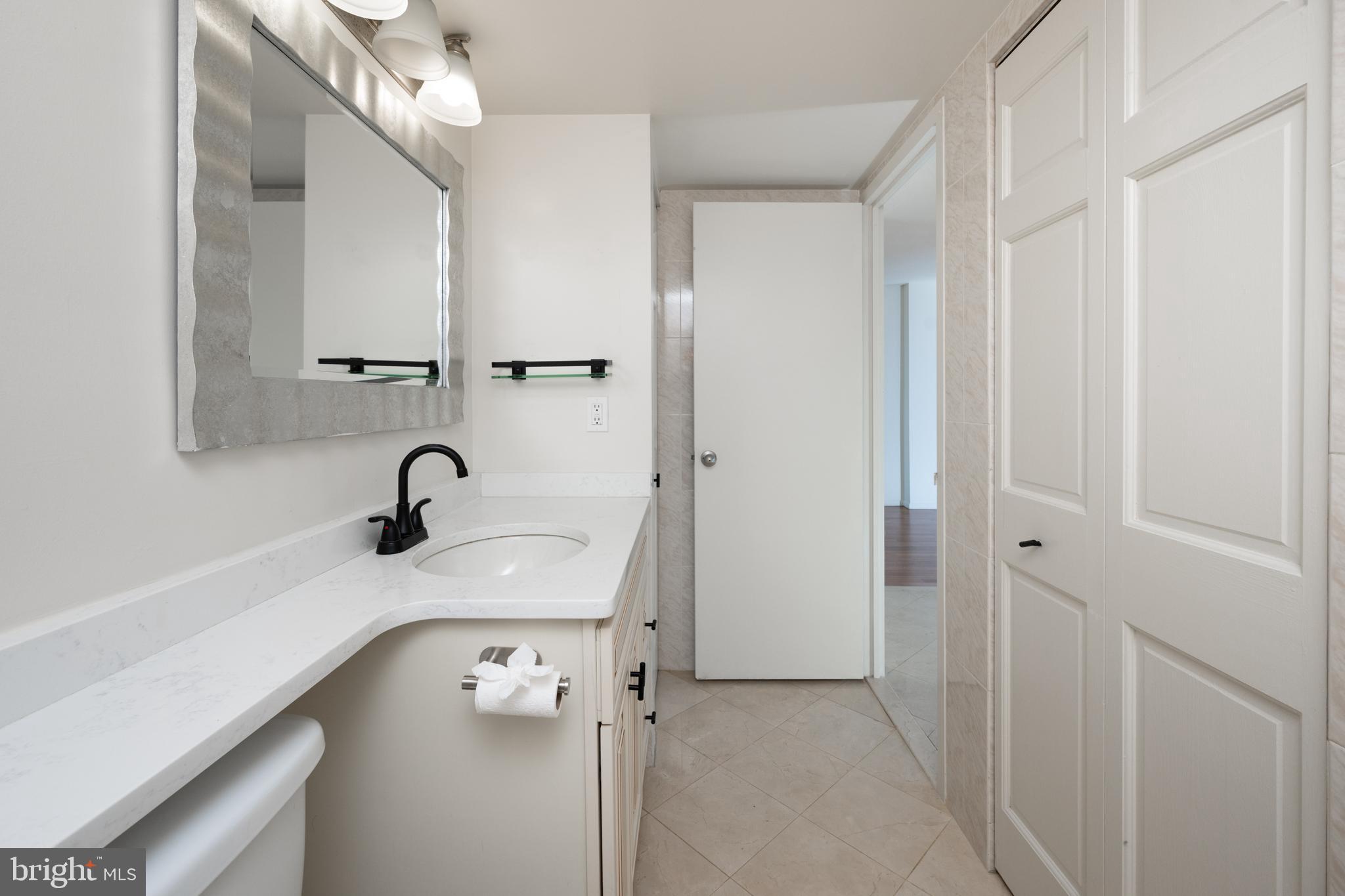 1420 Locust Street, Unit 24R Philadelphia, PA 19102 - Photo 21 of 31 a bathroom with a sink a mirror and shower