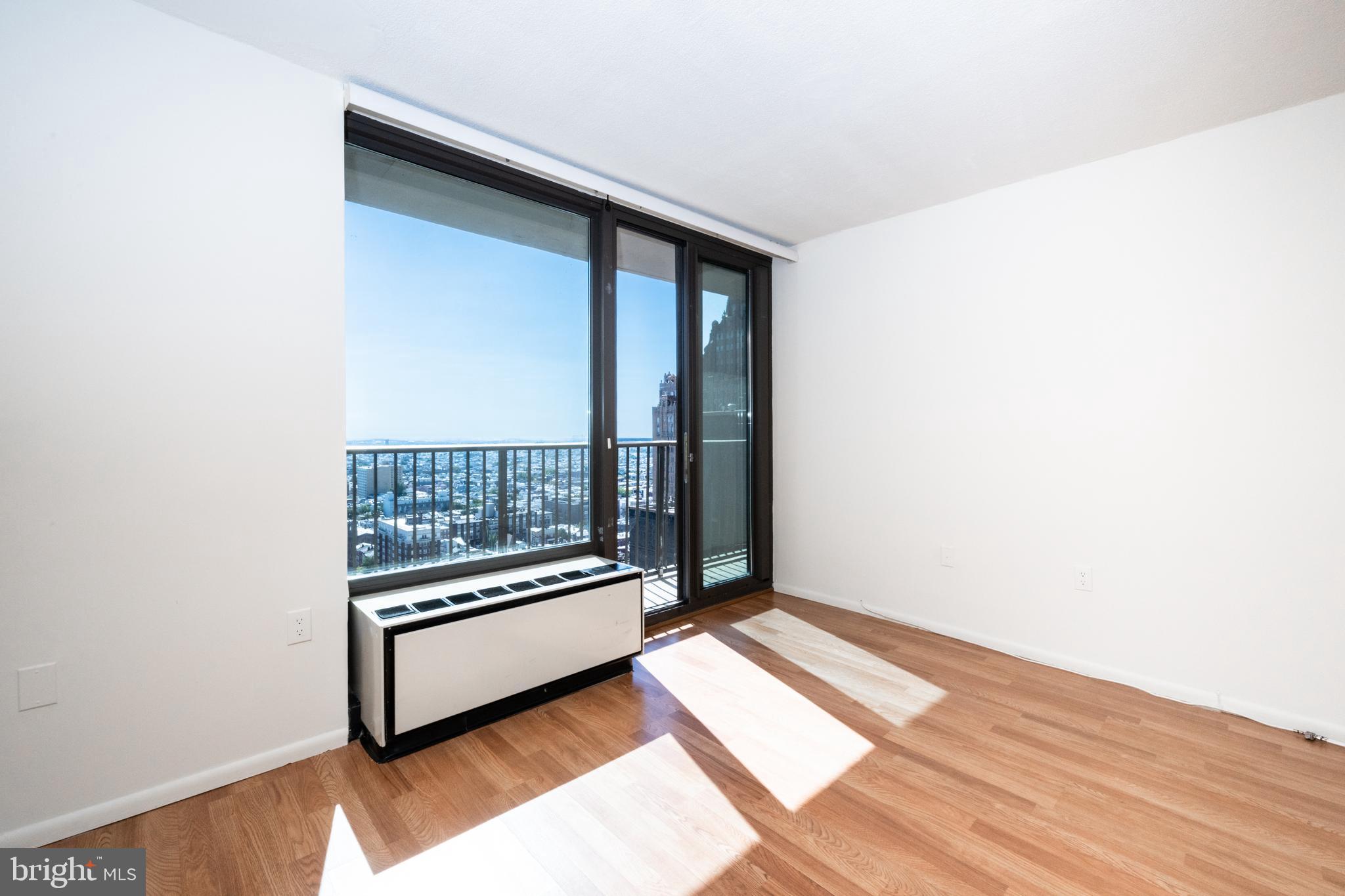 1420 Locust Street, Unit 24R Philadelphia, PA 19102 - Photo 6 of 31 a view of a room with wooden floor and a floor to ceiling window