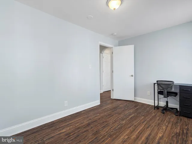 a big room with wooden floor and a window