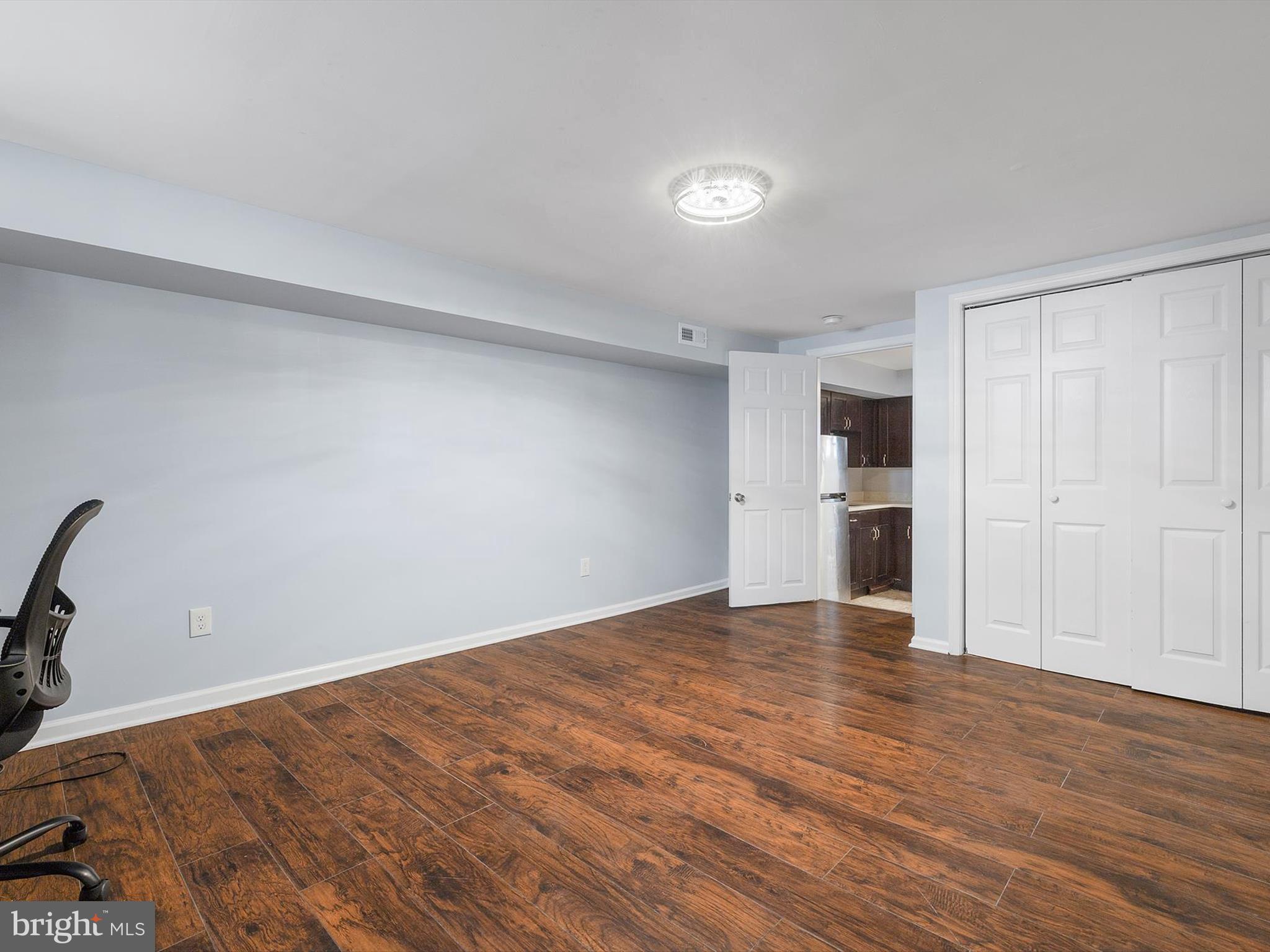1713 East Lafayette Avenue Baltimore, MD 21213 - Photo 23 of 29 a view of empty room with wooden floor and kitchen