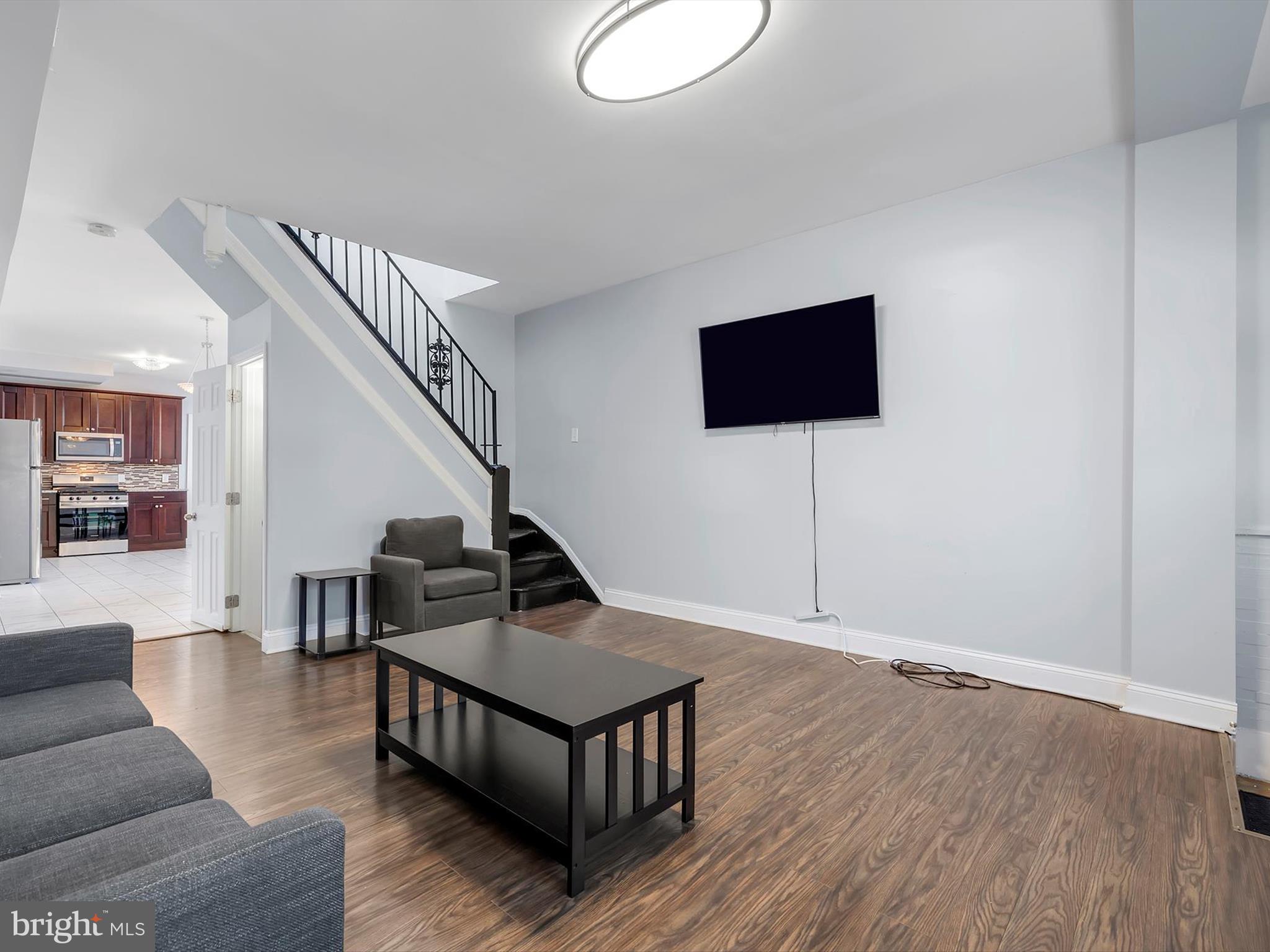 1713 East Lafayette Avenue Baltimore, MD 21213 - Photo 6 of 29 a living room with couches and a flat screen tv