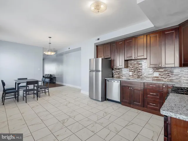 a kitchen with stainless steel appliances granite countertop a stove top oven a refrigerator a sink and a granite counter tops