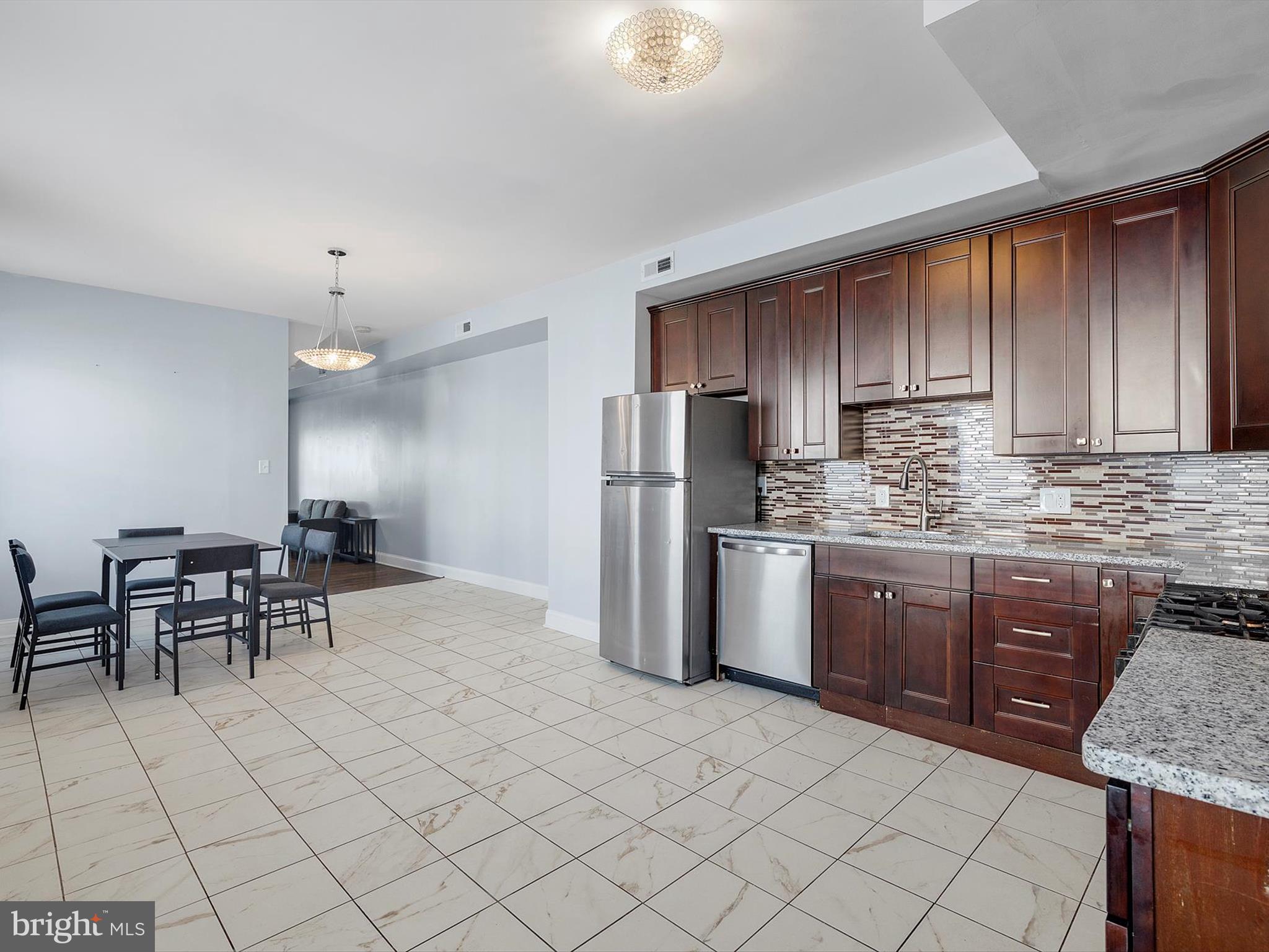 1713 East Lafayette Avenue Baltimore, MD 21213 - Photo 7 of 29 a kitchen with stainless steel appliances granite countertop a stove top oven a refrigerator a sink and a granite counter tops