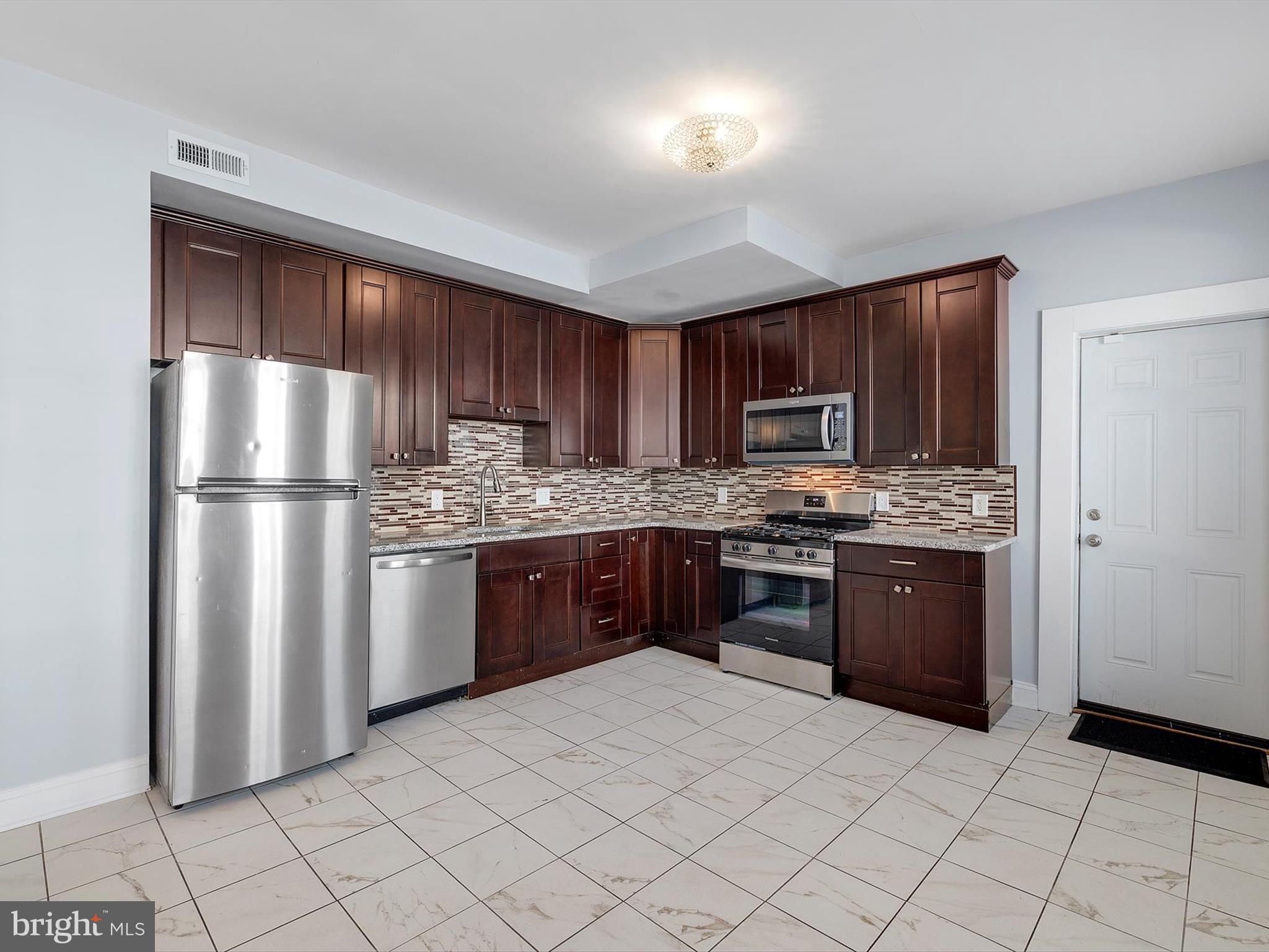 1713 East Lafayette Avenue Baltimore, MD 21213 - Photo 8 of 29 a kitchen with stainless steel appliances granite countertop a refrigerator sink and stove