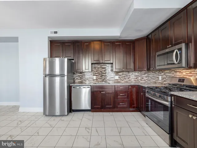 a kitchen with stainless steel appliances granite countertop a refrigerator sink and cabinets