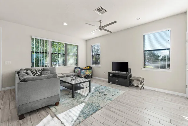 a living room with furniture and a wooden floor