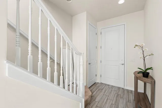 a view of a hallway with wooden floor and a window