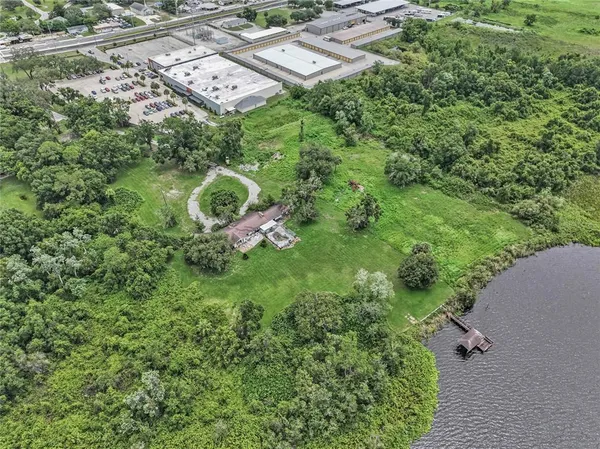 an aerial view of residential house with outdoor space and trees all around