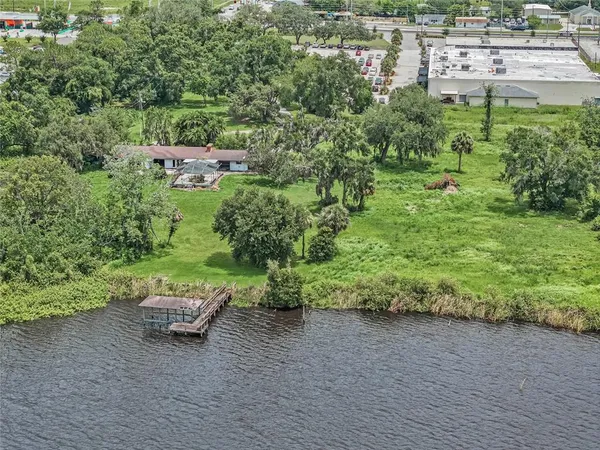 an aerial view of a house with a yard and lake view