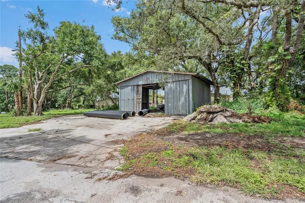 a view of a house with a yard and large tree