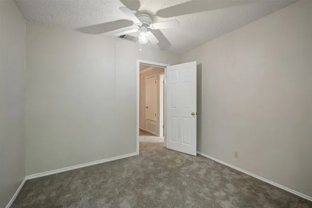 an empty room with a chandelier fan and closet