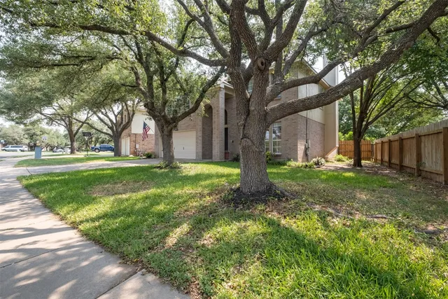 a view of a house with yard and tree s