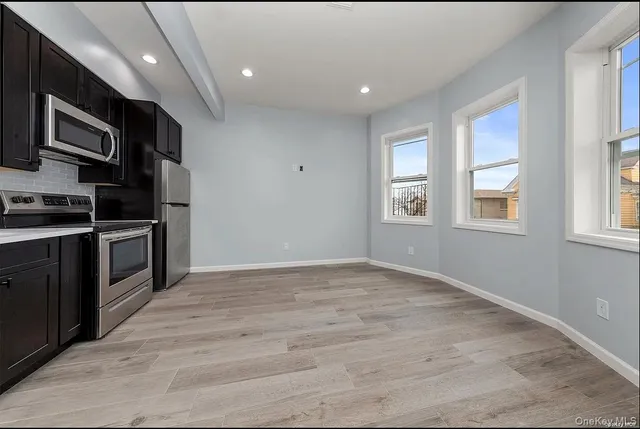 a view of kitchen with kitchen island granite countertop stainless steel appliances stove sink and cabinets