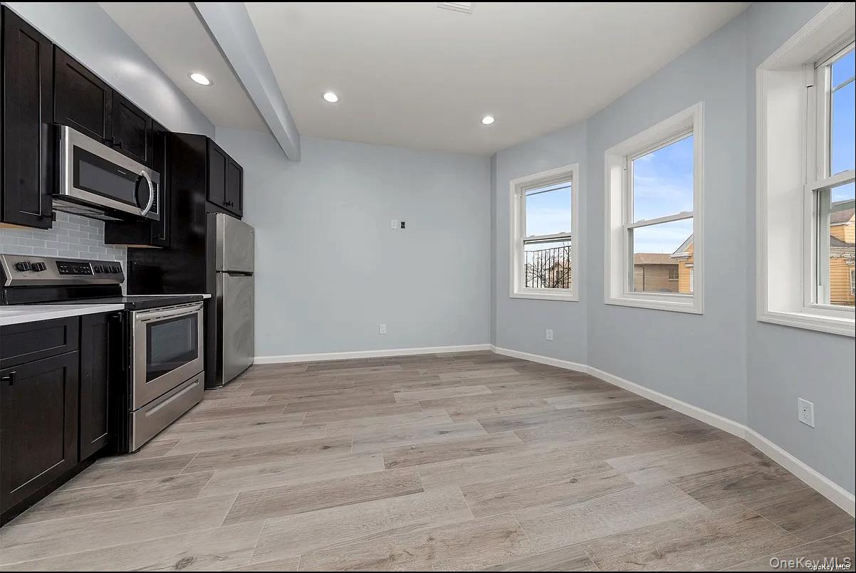a view of kitchen with kitchen island granite countertop stainless steel appliances stove sink and cabinets