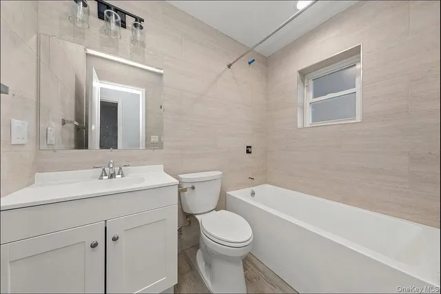 a bathroom with a toilet a sink a mirror and vanity
