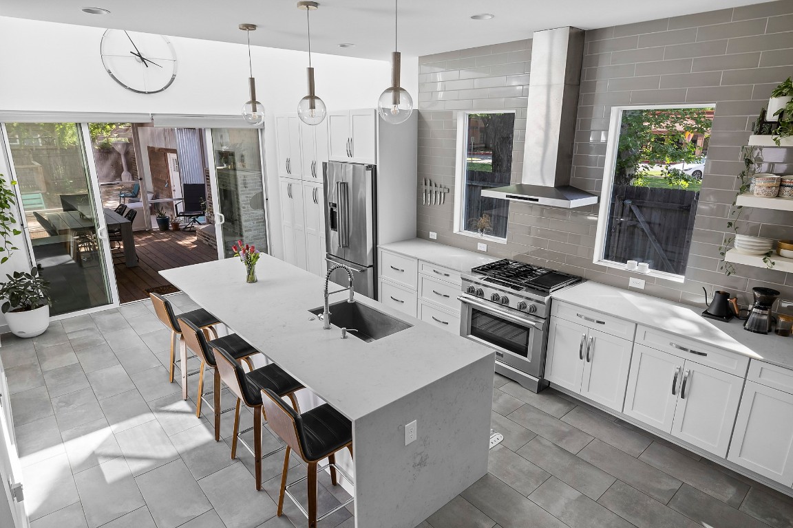 a kitchen with stainless steel appliances a table chairs and a refrigerator