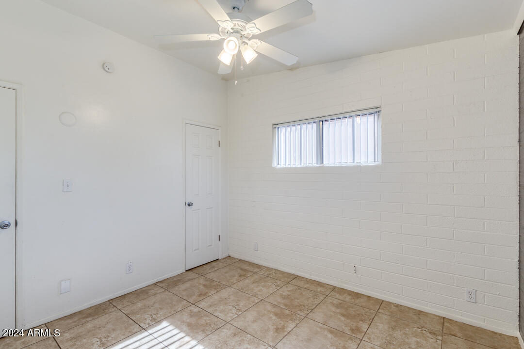 1921 East Virginia Avenue, Unit 14 Phoenix, AZ 85006 - Photo 12 of 20 an empty room with a window and a fan