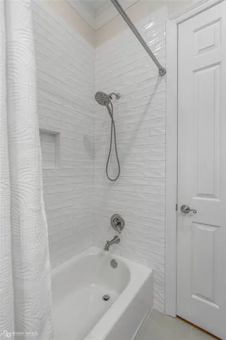 a bathroom with a bath tub with a shower