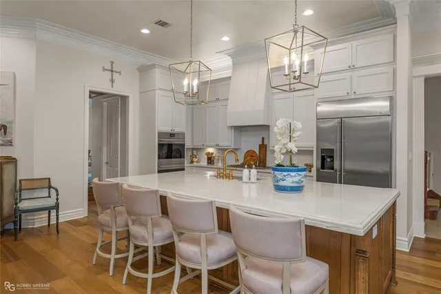 a kitchen with a dining table chairs stainless steel appliances and cabinets