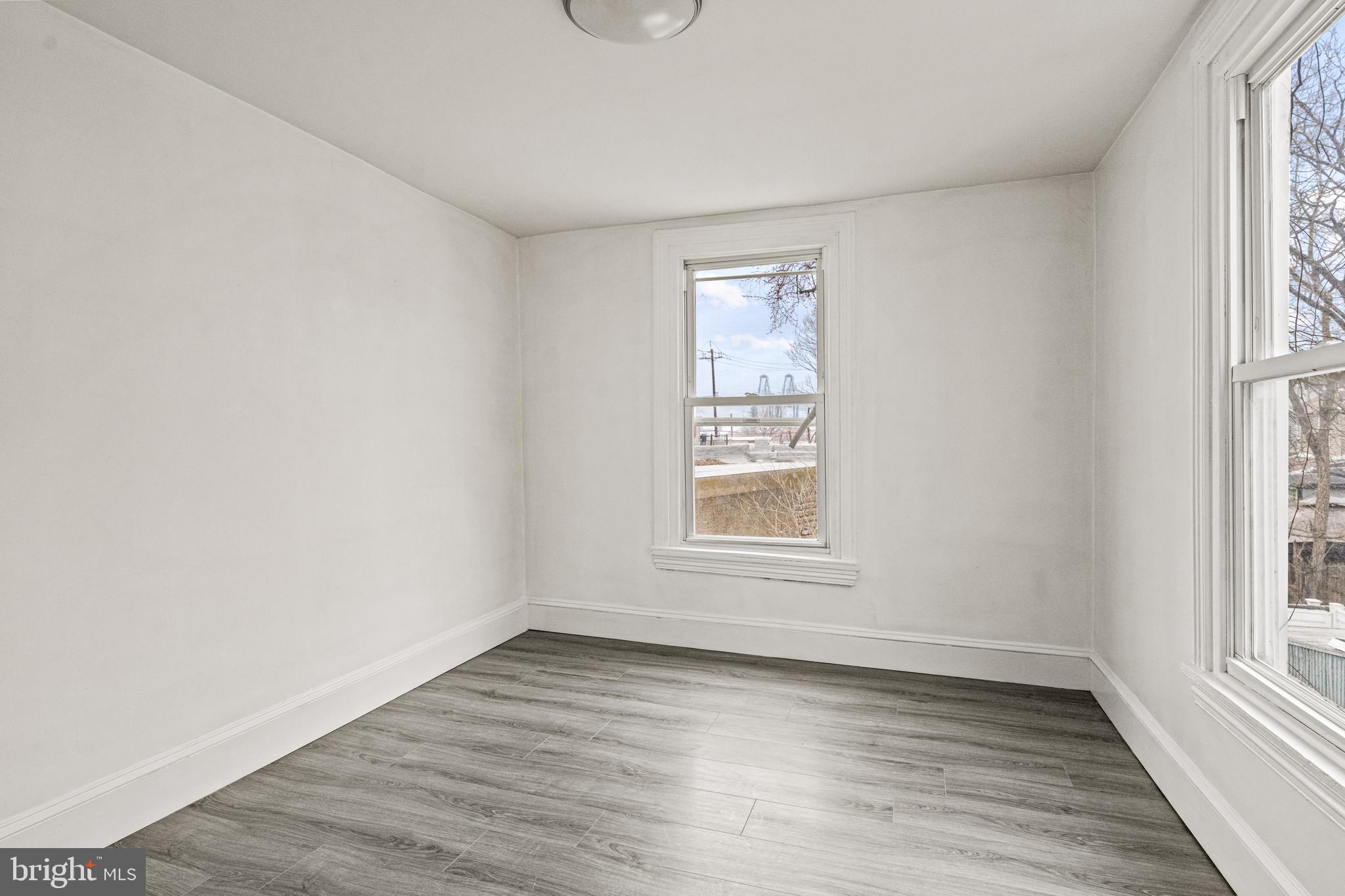239 3rd Street Gloucester City, NJ 08030 - Photo 17 of 20 an empty room with wooden floor and windows
