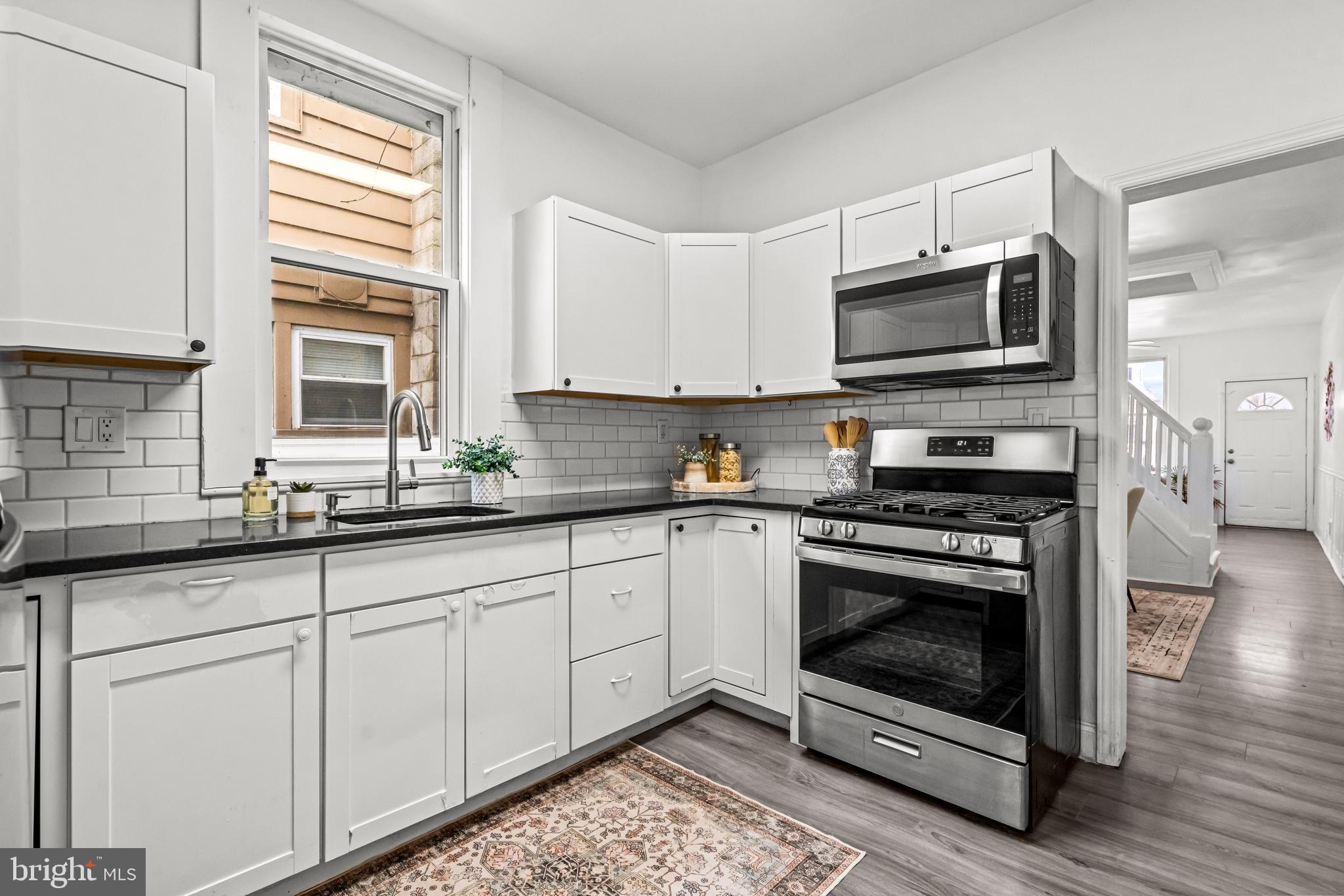 239 3rd Street Gloucester City, NJ 08030 - Photo 9 of 20 a kitchen with stainless steel appliances granite countertop a stove microwave and sink