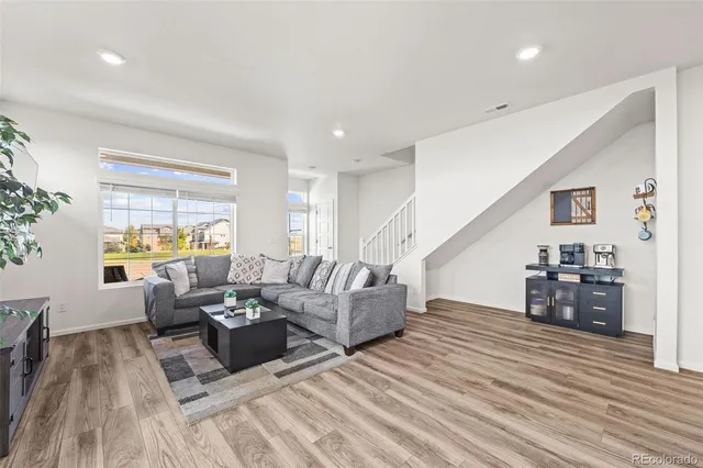 a living room with furniture and wooden floor