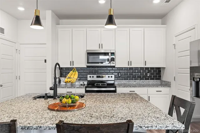 a kitchen with stainless steel appliances granite countertop a sink stove and cabinets