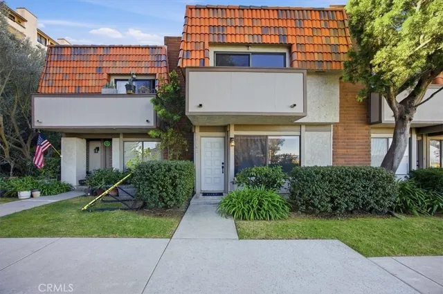 a view of a white house with a yard and plants