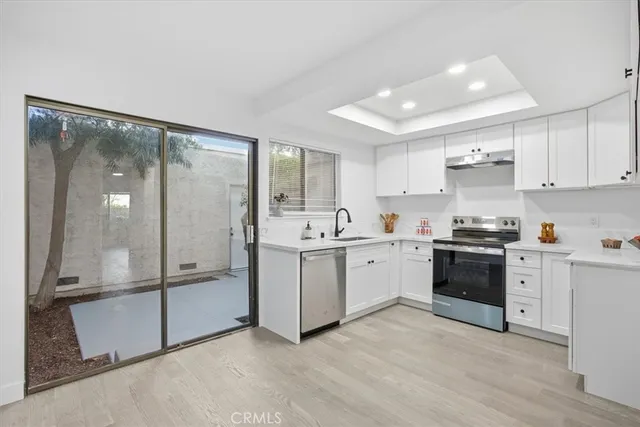 a kitchen with a sink stainless steel appliances and cabinets