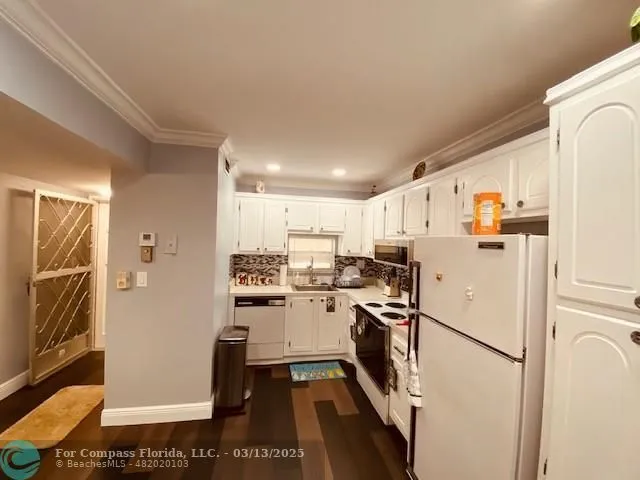 a kitchen with stainless steel appliances a refrigerator sink and white cabinets