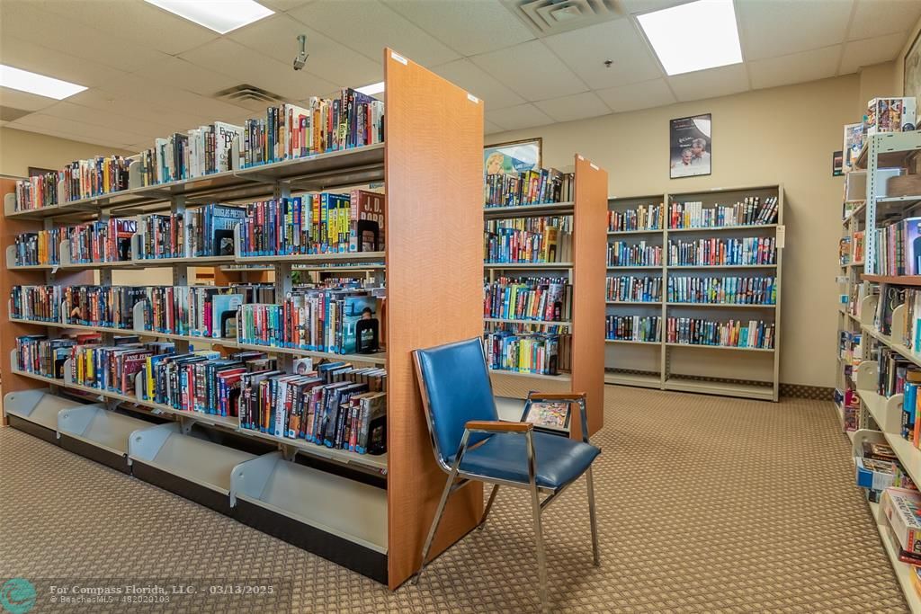 8990 South Hollybrook Boulevard, Unit 301 Pembroke Pines, FL 33025 - Photo 46 of 52 a living room with furniture and a book shelf