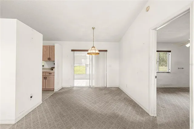 a view of an empty room with a kitchen