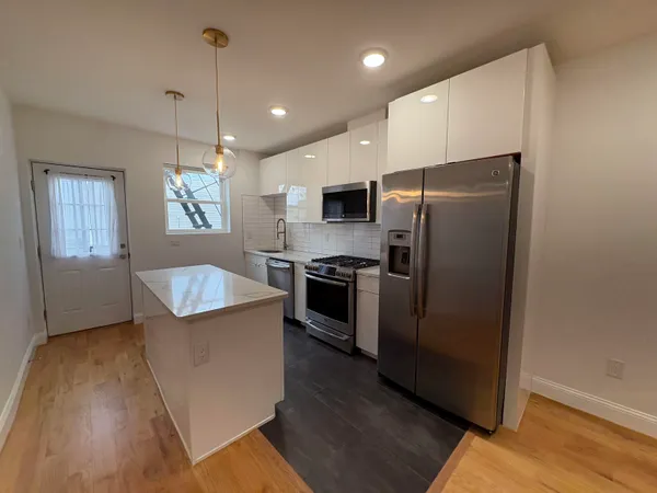 a kitchen with refrigerator cabinets and wooden floor
