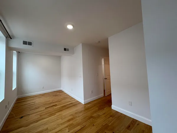 a view of empty room with wooden floor