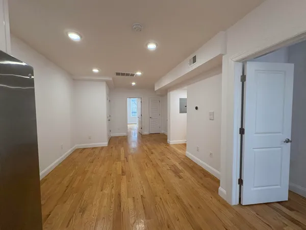 a view of empty room with wooden floor