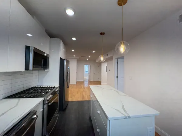 a large kitchen with stainless steel appliances kitchen island a large stove a sink a microwave and island