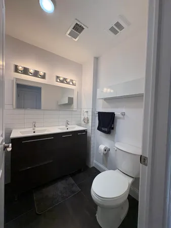 a bathroom with a toilet sink and mirror