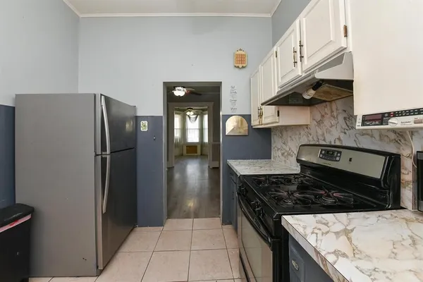 a kitchen with stainless steel appliances granite countertop a refrigerator a stove and a sink