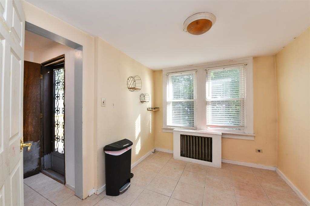 426 Hancock Place Fairview, NJ 07022 - Photo 4 of 14 a view of an empty room with blue walls and a window