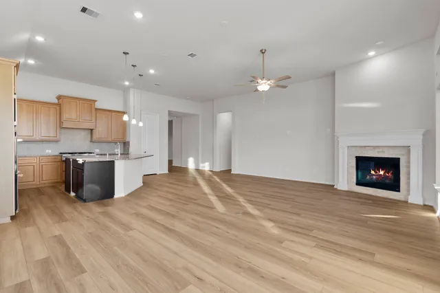 a open kitchen with kitchen island a sink stainless steel appliances and a fireplace