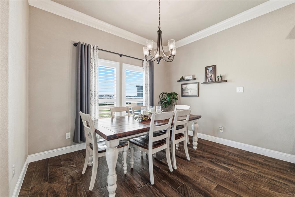 121 Bluff Ridge Court Paradise, TX 76073 - Photo 11 of 33 Dining room featuring crown molding, a chandelier, and dark wood-style flooring