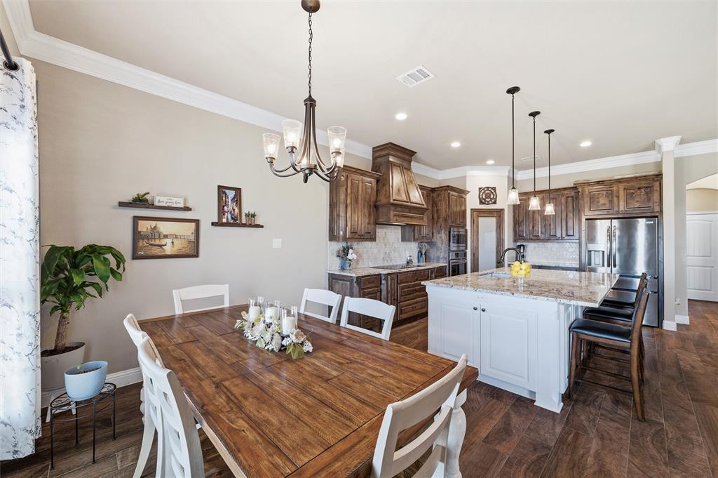 121 Bluff Ridge Court Paradise, TX 76073 - Photo 12 of 33 Dining room with dark wood-type flooring, a chandelier, and ornamental molding